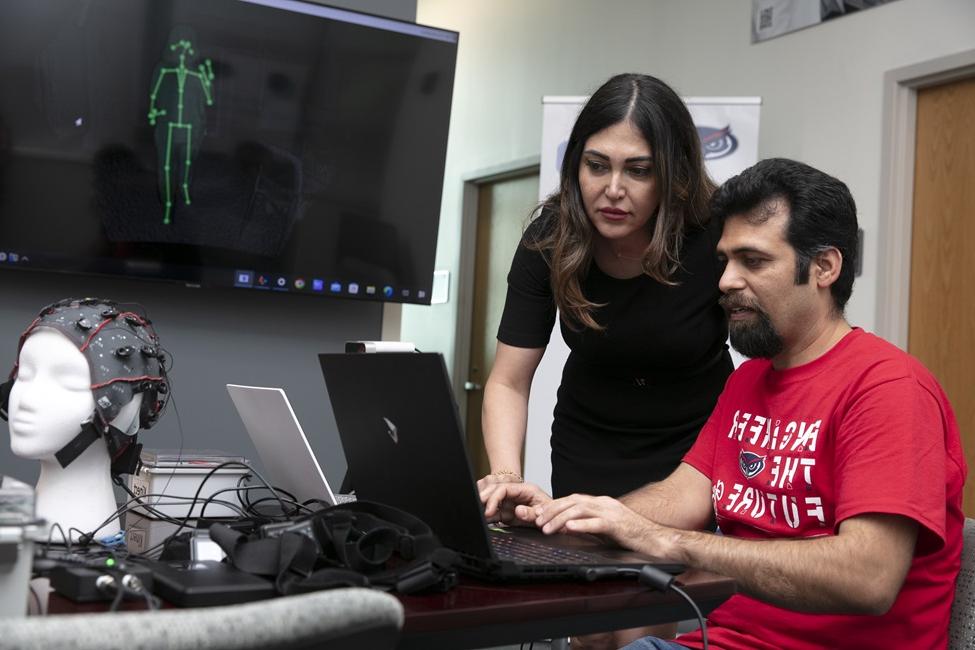 Mahmoud Seifallahi (seated) and Behnaz Ghoraani, Ph.D., review the performance of straight walking using a depth camera, which can detect and track 25 joints of body movement.